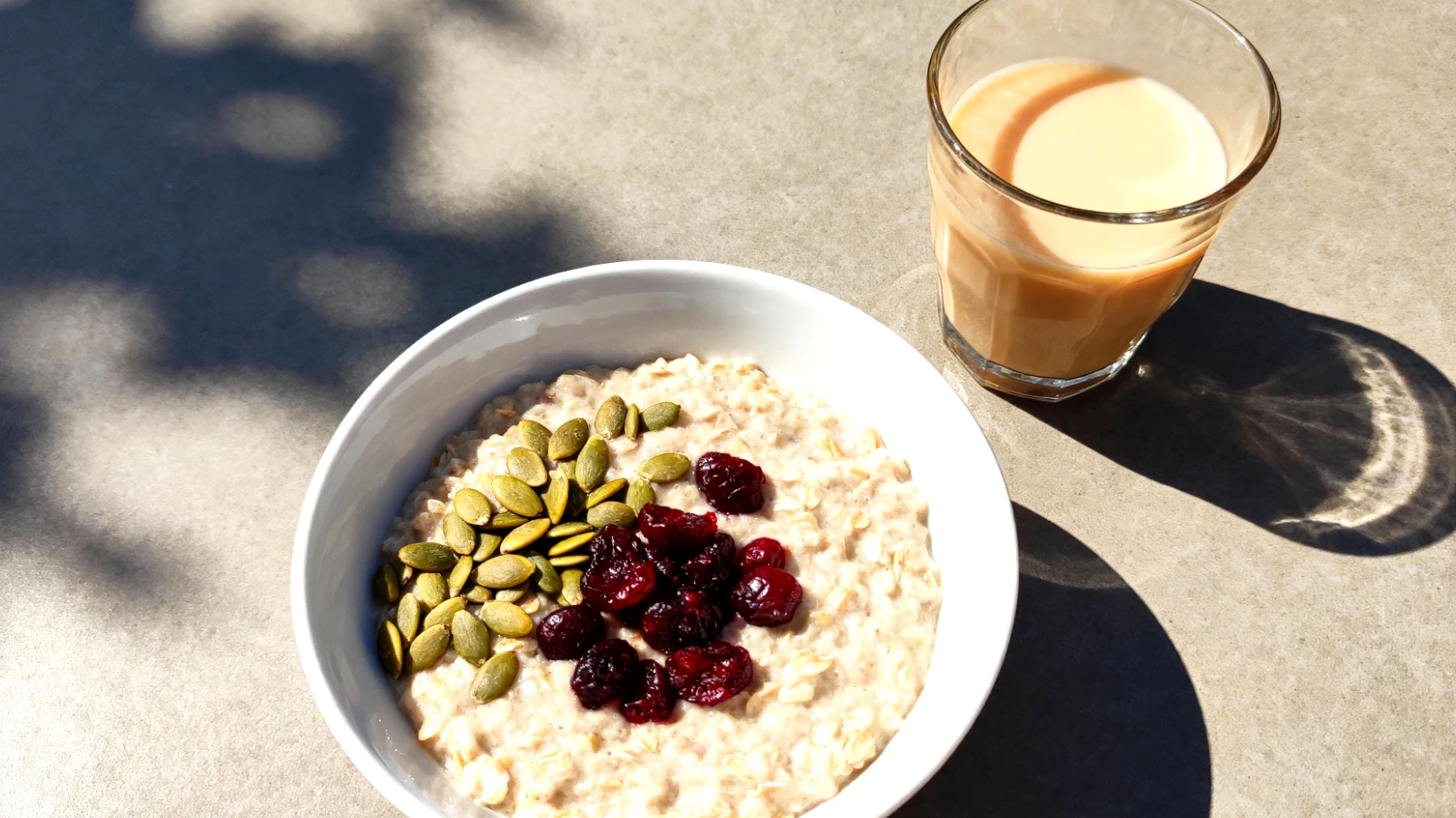 Porridge di avena con semi di zucca, ciliegie essiccate e latte tiepido"