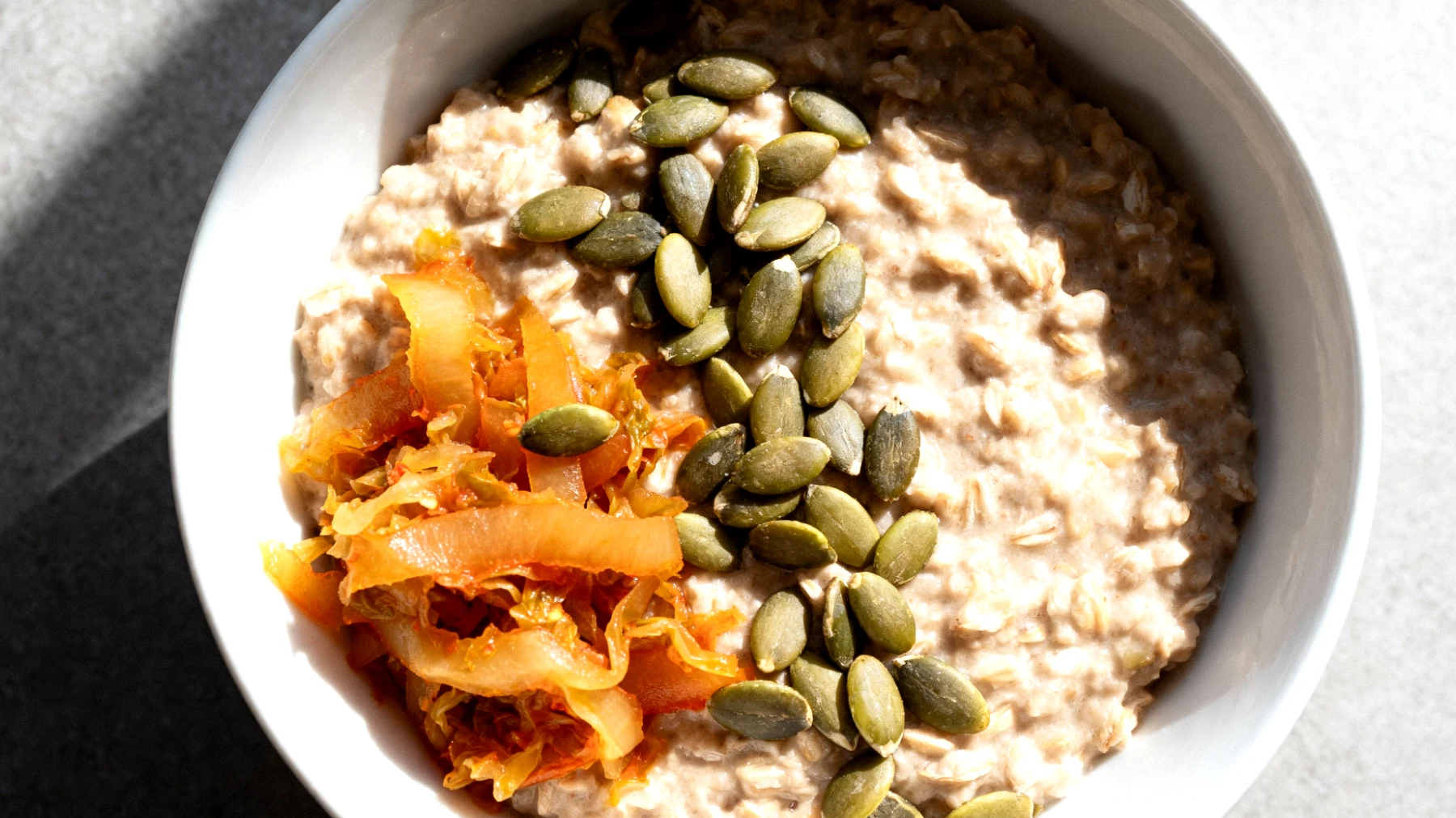 Porridge salato con avena integrale, semi di zucca e verdure fermentate"